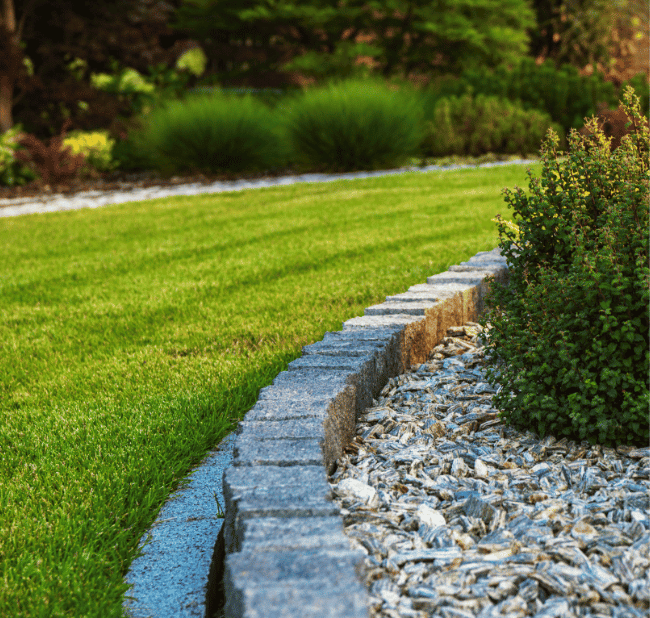 Gartengestaltung mit Rasenfläche und Natursteinkante in Paderborn